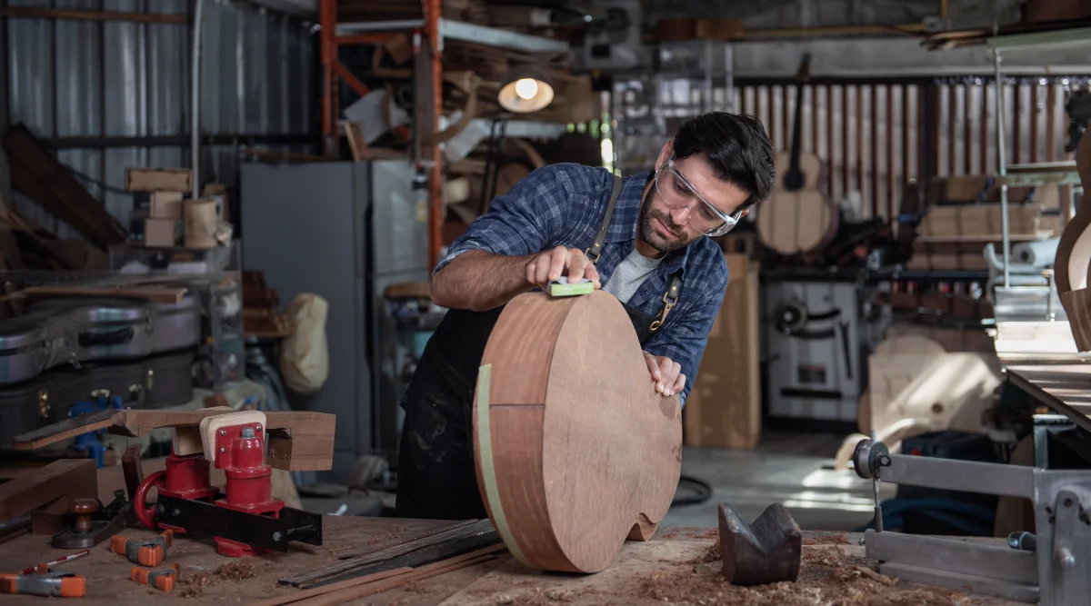 Man polishes his guitar as he comtemplates small business grants 