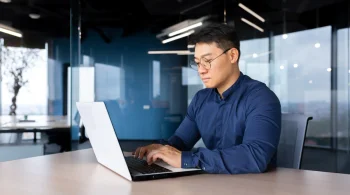 Man working on a laptop in a modern office setting