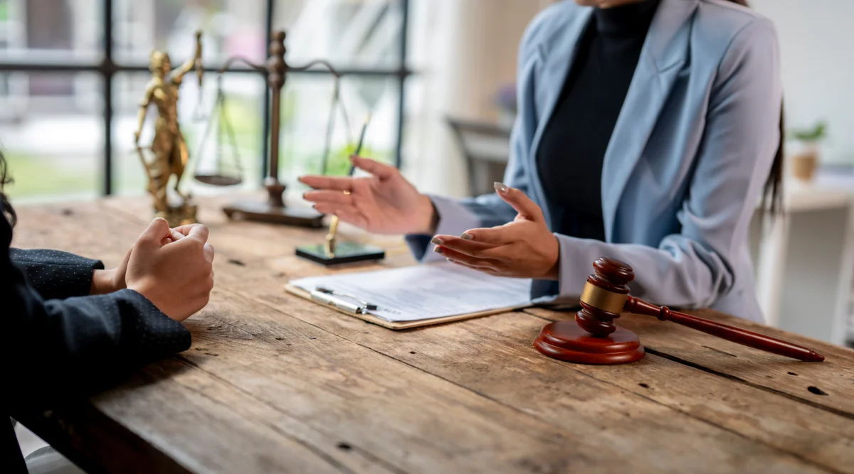 Two people talking about legal items at a beautiful barn wood table.