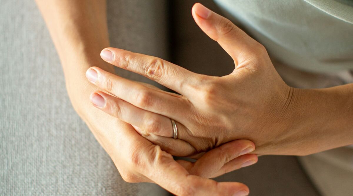 Close up of a woman's hands, prominently showing her wedding band.