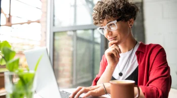 A woman wearing glasses researching what happens after you serve your spouse divorce papers on her laptop.