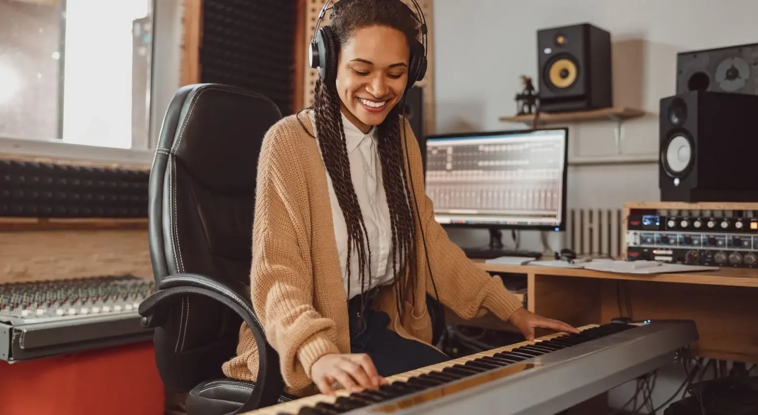 A musician uses a soundboard in her studio.