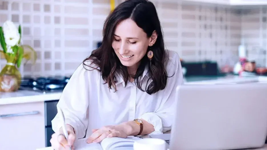 A woman takes notes in an online meeting with her attorney, who tells her about how trusts are taxed and the tax benefits of trusts.