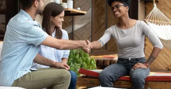 A couple meets and shakes hands with their future wedding planner.