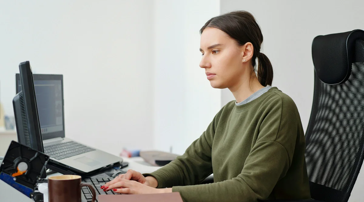 Woman focused on computer screens at a desk