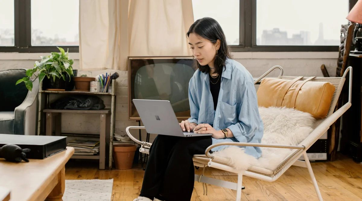 Woman working on a laptop in a cozy room