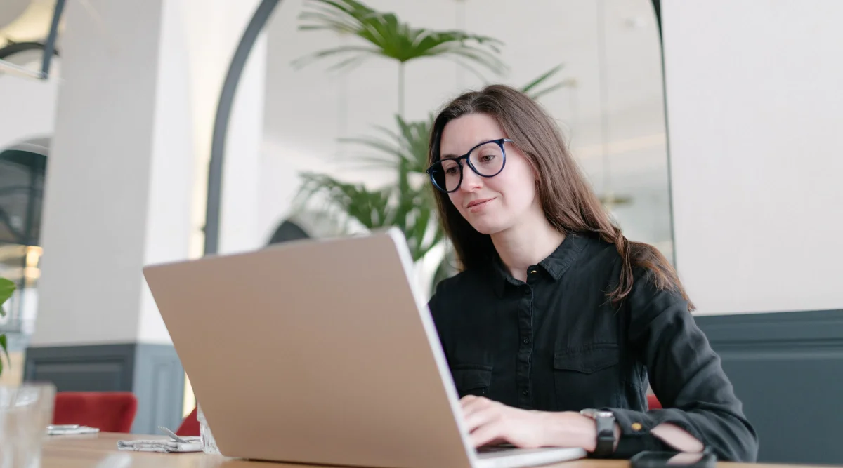 Woman in glasses using a laptop in a modern space