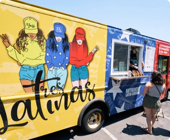 Colorful mural of three girls on a yellow truck