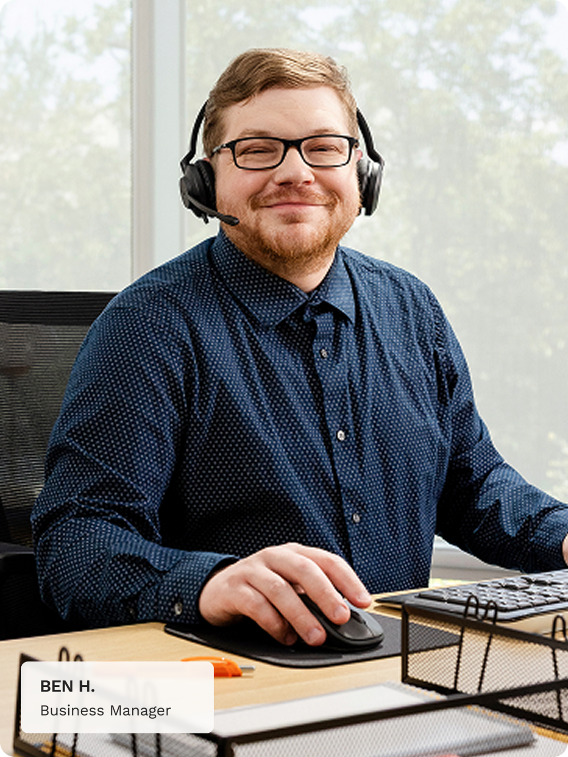 Ben H. Business Manager sits at a desk. 