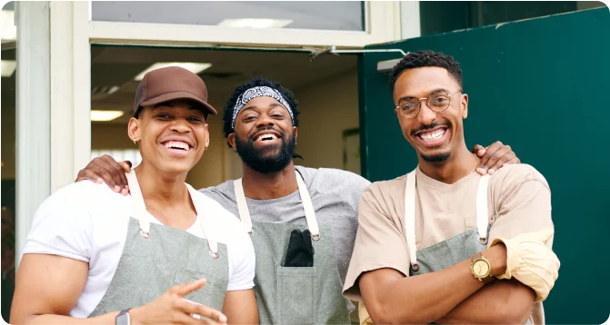 Jovial employees pose for a photo outside of restaurant