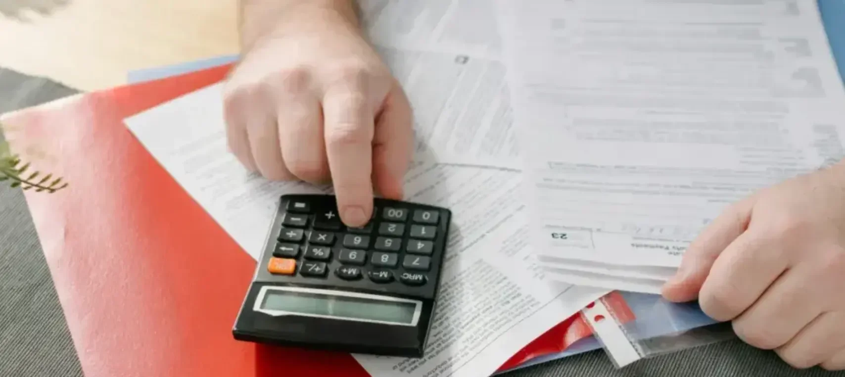 A small business owner in Delaware uses his calculator to add up figures and fill out paperwork for his registered agent. 