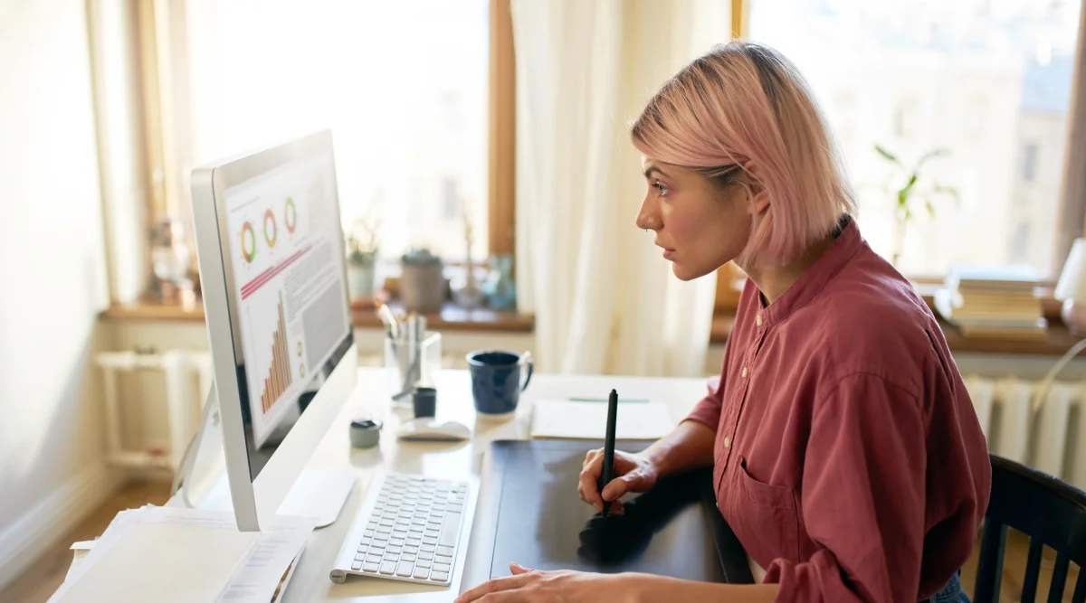 Woman with pink hair working on a desktop