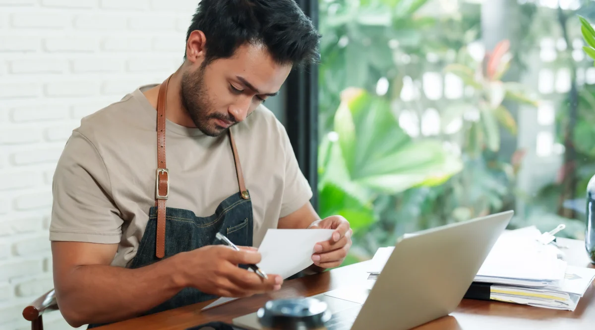 A pottery studio business owner sits at his desk and reviews his trademark application.