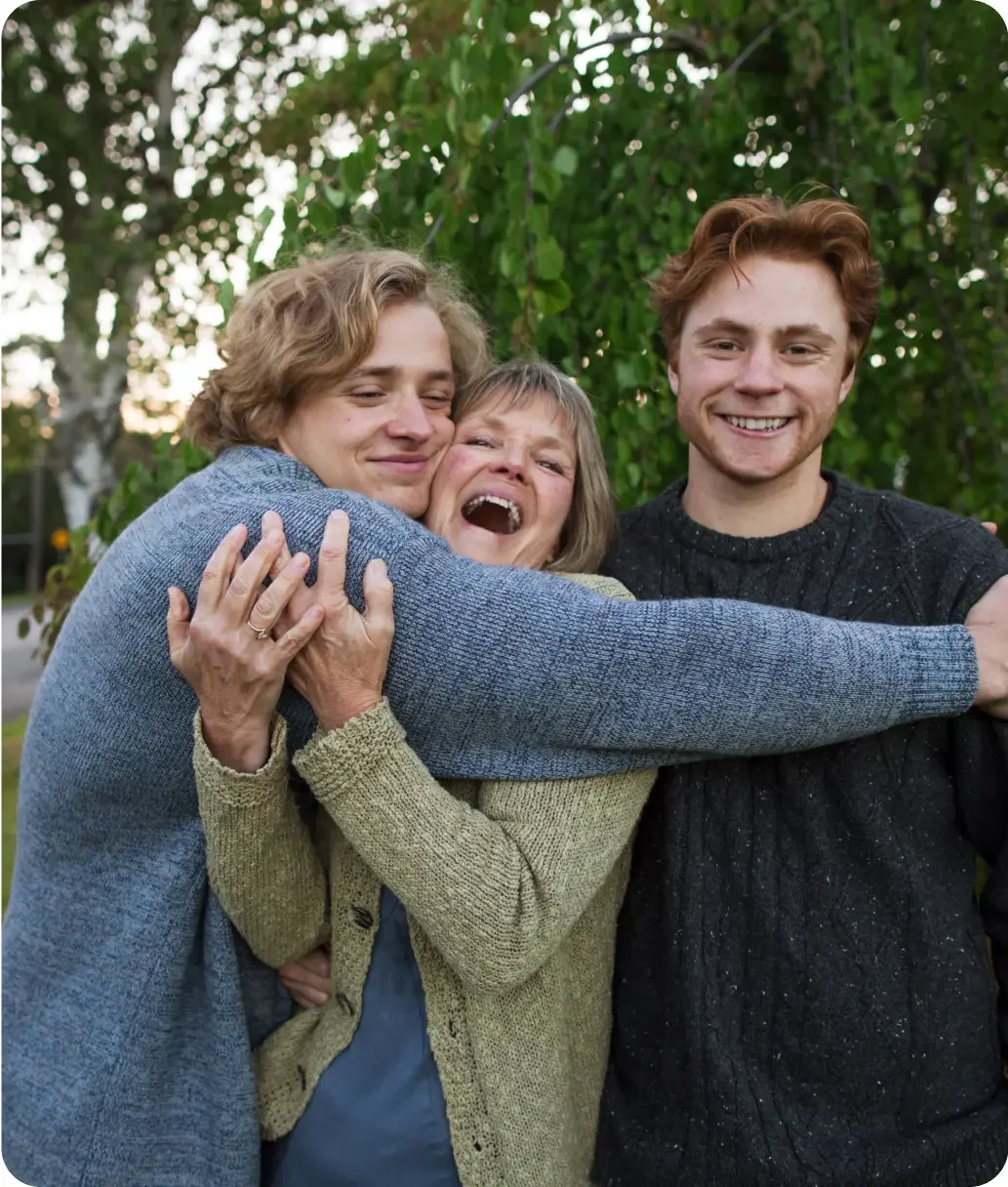 Man embraces sons in a playful hug