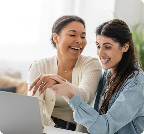 Two young women working together on their laptop