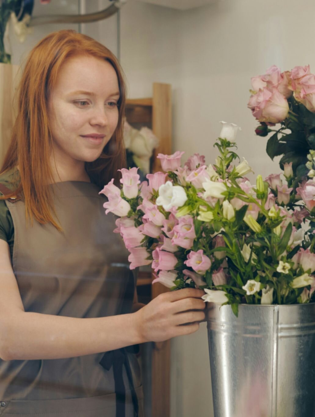 A florist makes an arrangement in her shop