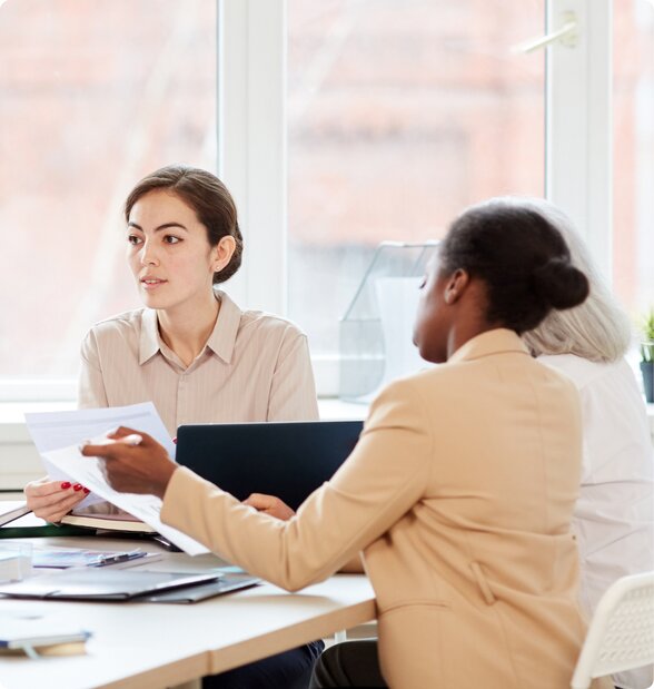 3 women sitting in a conference room looking at dissolution paperwork created with LegalZoom.