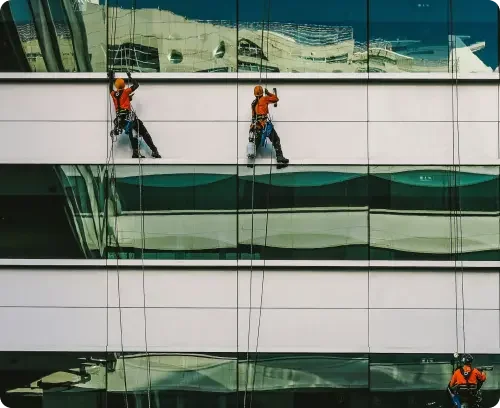 Workers in harnesses performing maintenance on the side of a building. These workers were hired to fulfill maintenance obligations within the commercial lease agreement for the building.