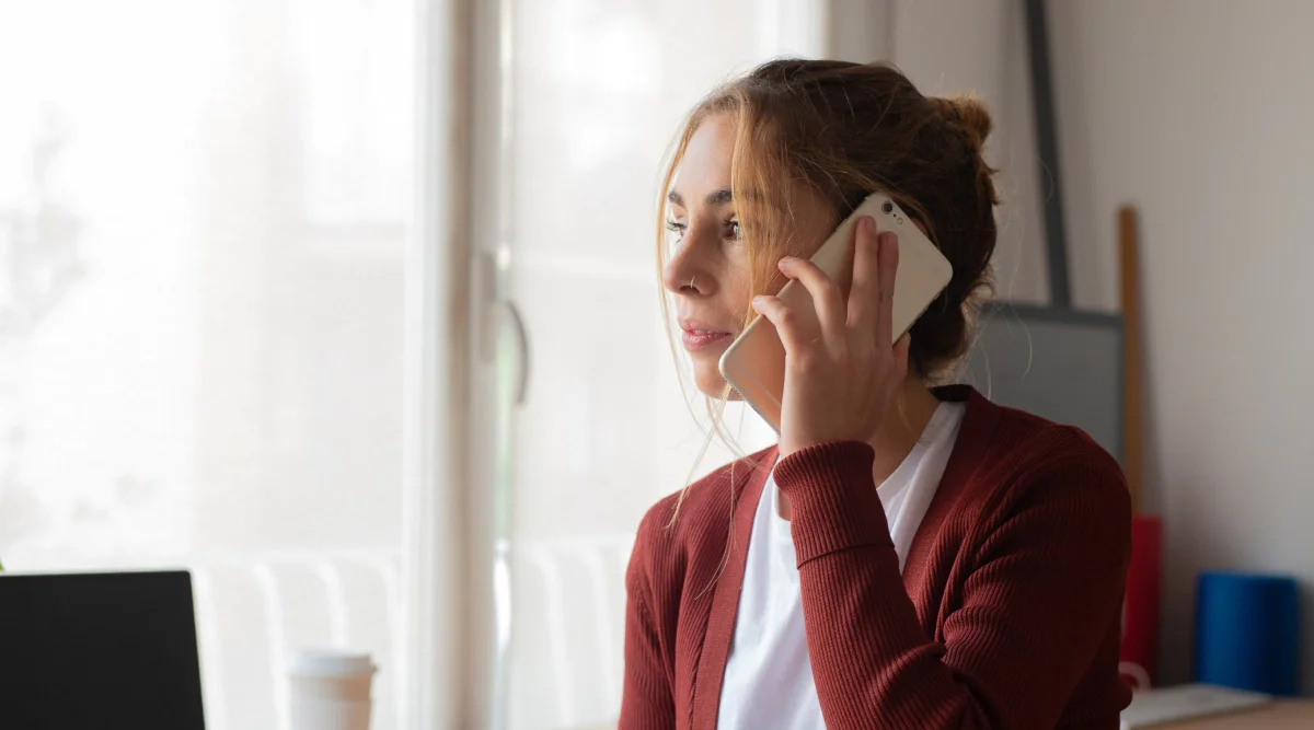 Woman on phone, looking out window