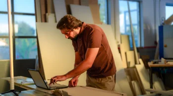 Man working on a laptop in a workshop