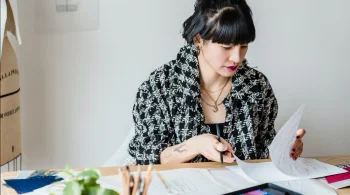 Person working at a table, focused on paper documens