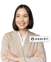 A family law attorney standing and smiling with her arms crossed with assist badge