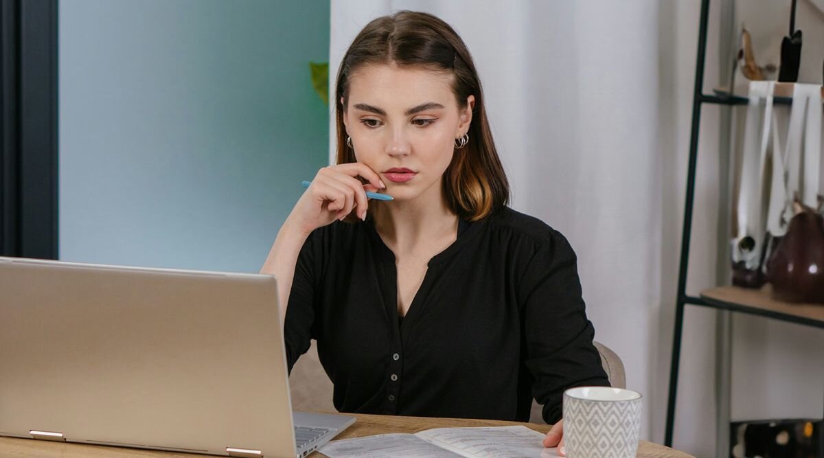 A woman sits at a laptop and reviews an arbitration agreement in her employment contract.