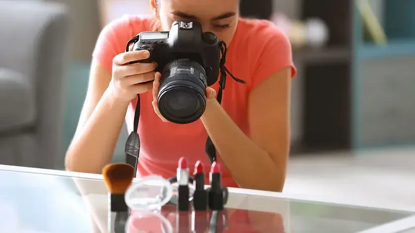 Close up of a woman taking pictures of cosmetics.