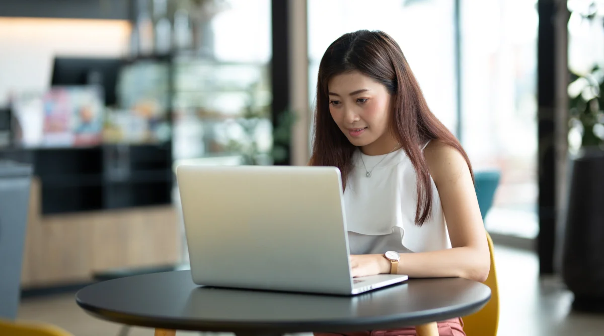 Woman working on a laptop in a modern cafe setting