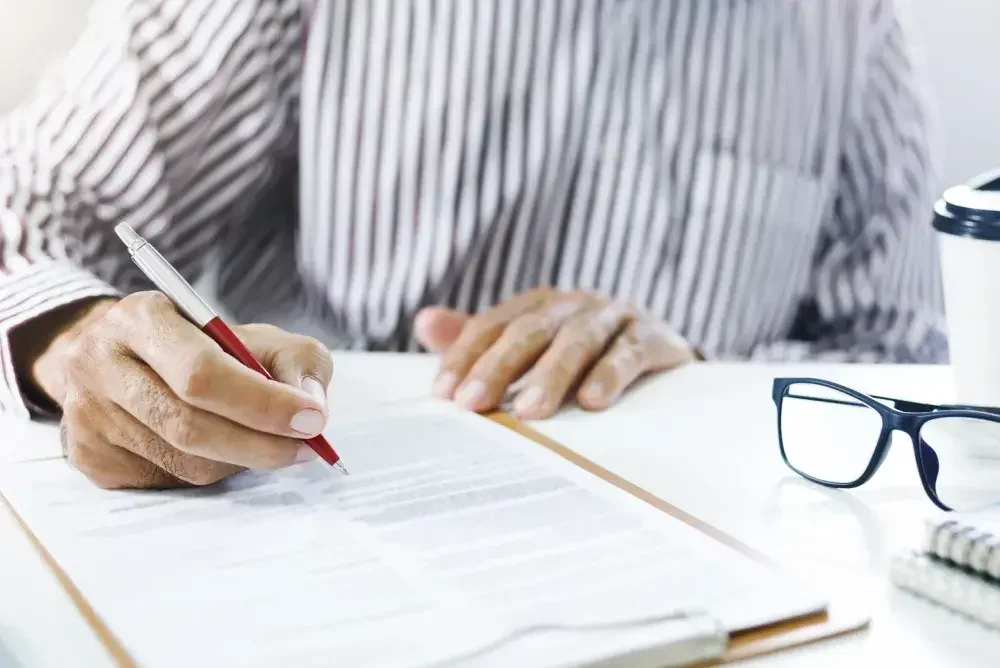 A zoomed-in picture of someone filling out a form on a clipboard. 