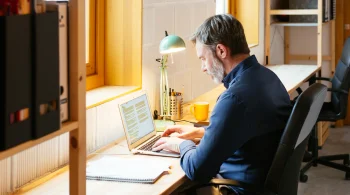 Man typing on laptop in a cozy workspace