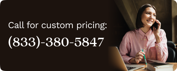 Woman in a pink blouse sitting at her desk, talking on the phone