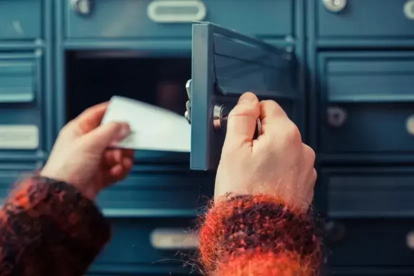 a person pulling out mail from the mailbox