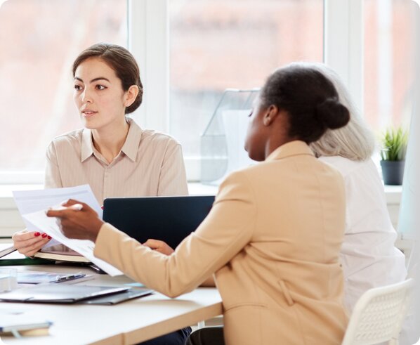 3 women sitting in a conference room looking at dissolution paperwork created with LegalZoom.