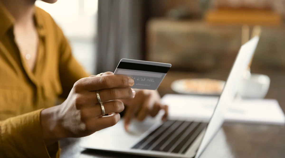 Woman sits in her sunroom and uses her laptop to research what you need to open a DBA bank account