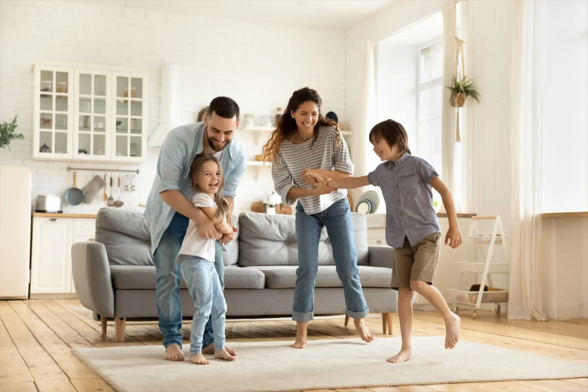 A husband and wife with two minor children playing and enjoying a fun family time, illustrating the concept of primary beneficiaries.