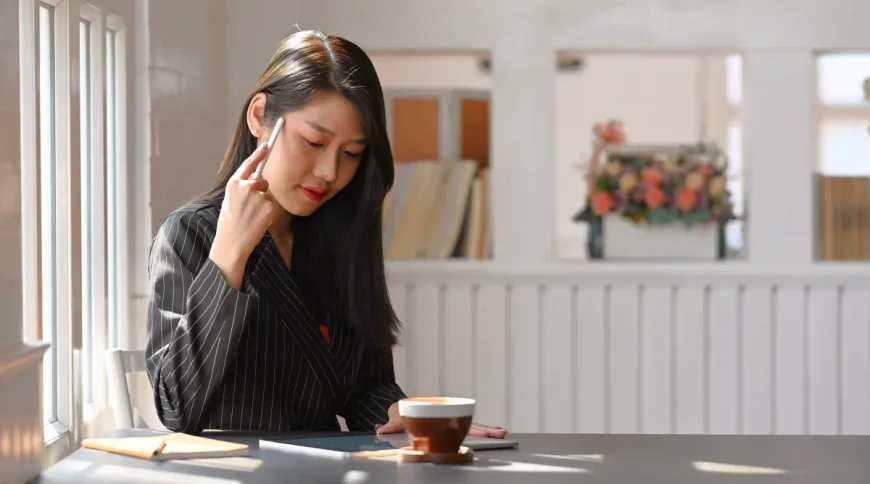 A woman sits at a counter and looks down at her tablet, where she reads instructions to form a California business