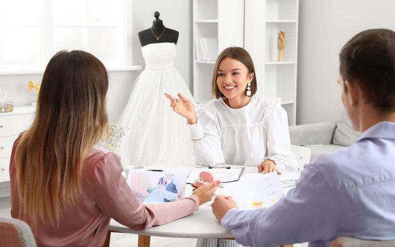 An image of a wedding planner explaining their services to the customers.