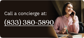 Woman in a pink blouse sitting at her desk, talking on the phone