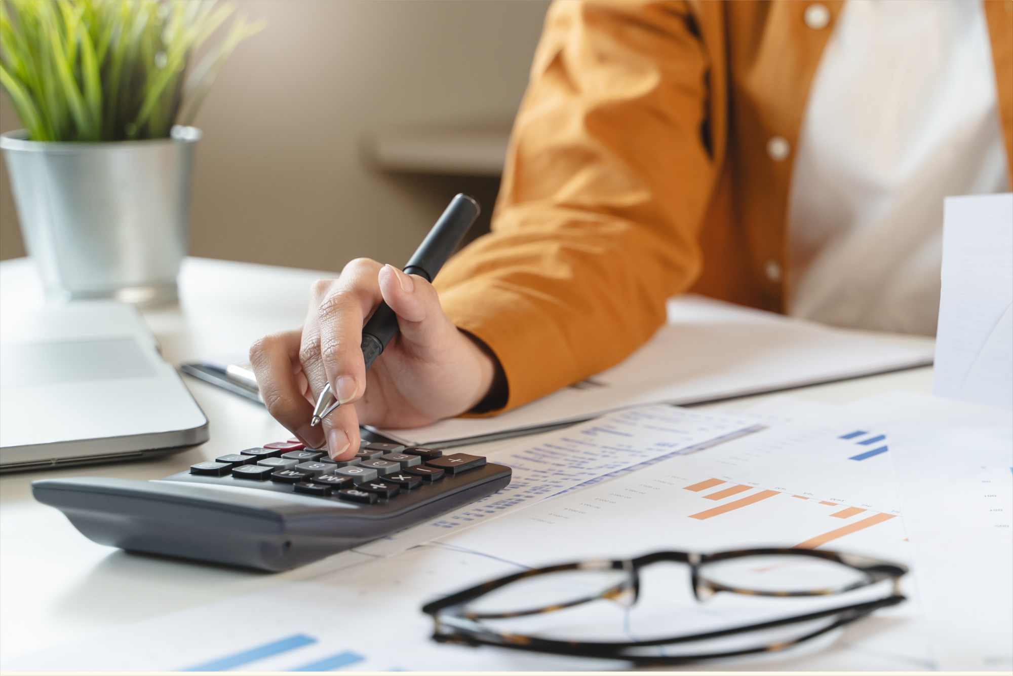 A picture of a person wearing a yellow open shirt, calculating and noting down his assets and inheritances for tax filing and other documentation purposes.