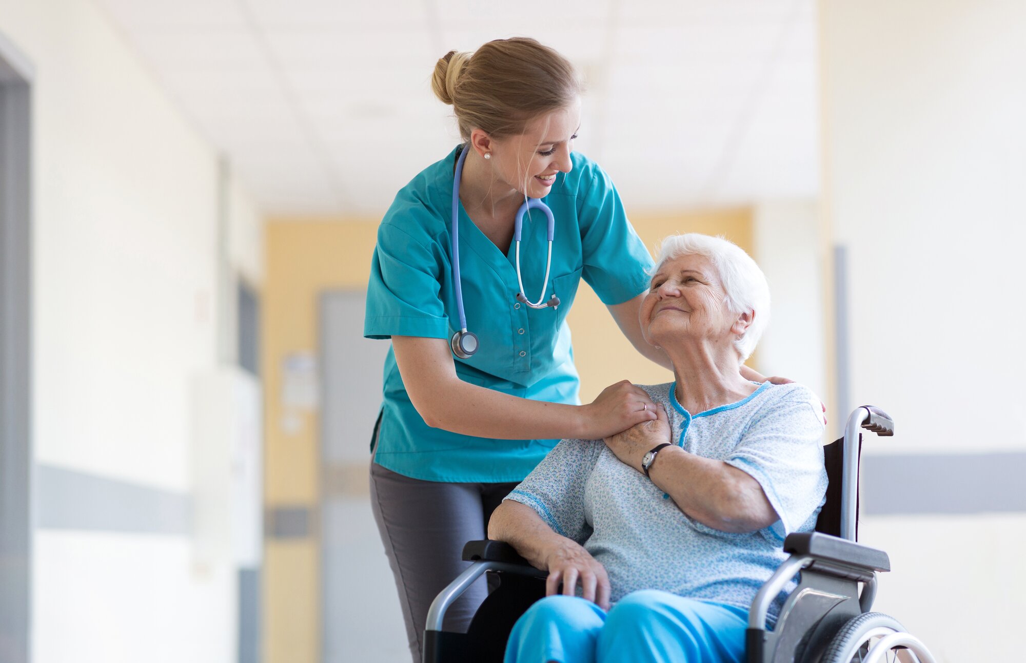 An image of a patient in a wheelchair smiling and informing a nurse about the DNR form before surgery.