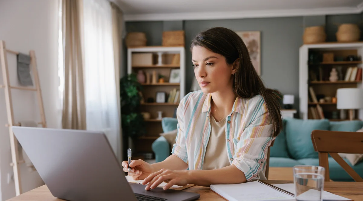 Woman concentrating on a laptop at a cozy home desk