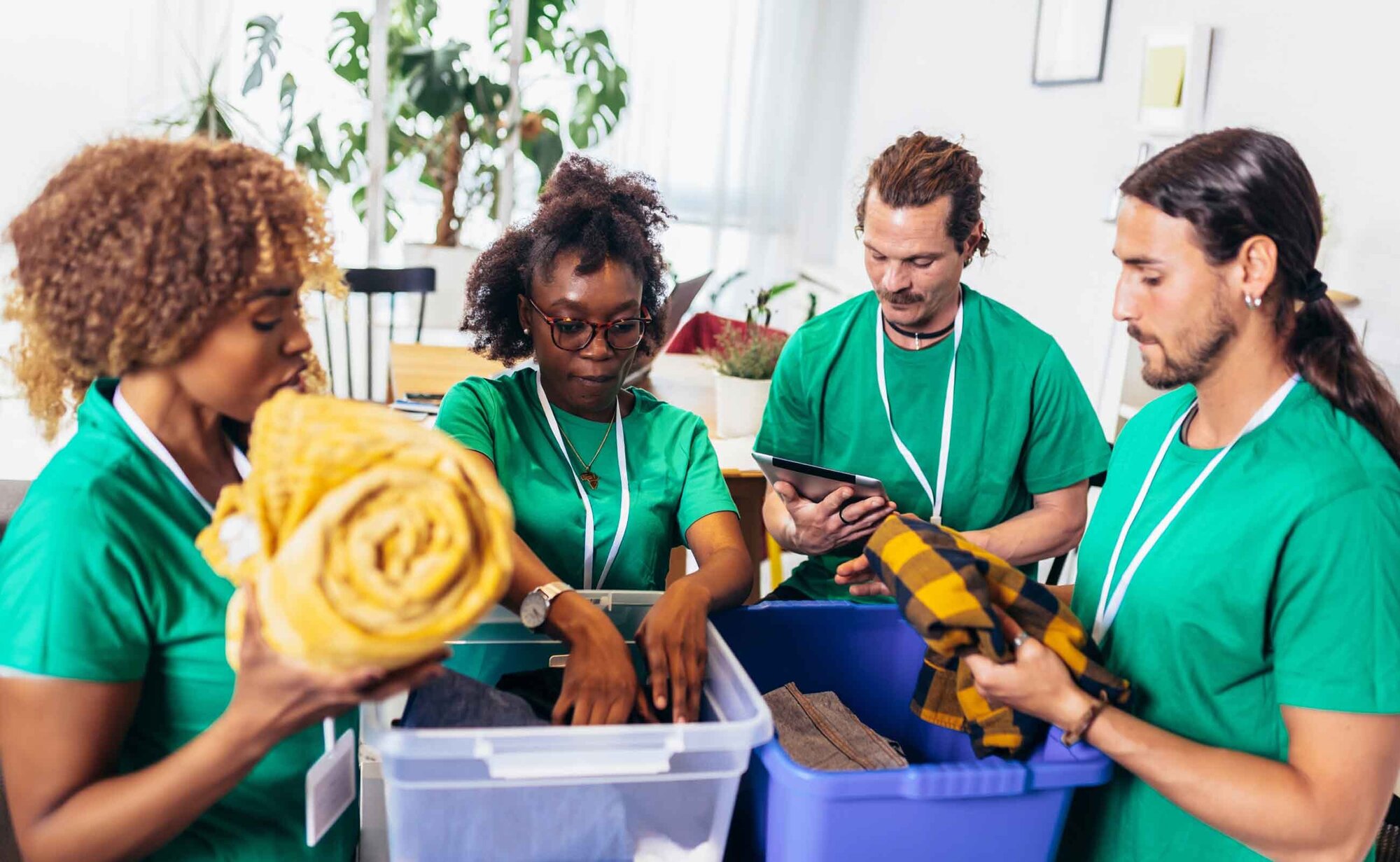 An image of a group of volunteers dressed in green t-shirts packing clothes.