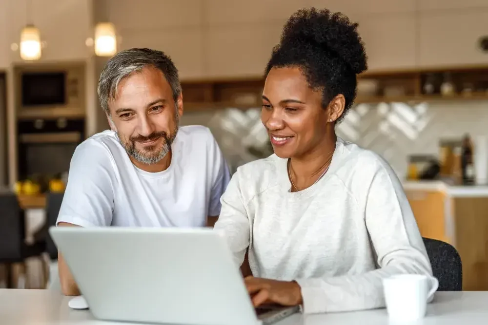 A couple investigates online wills while seated at their kitchen counter. Online will creation services are a smart way to get your will done.