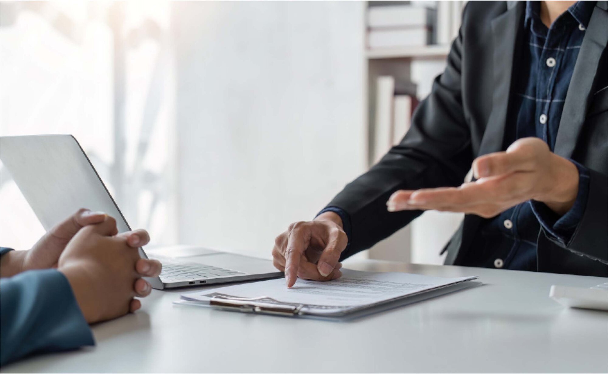 An image of a salesperson explaining an agreement to a customer in an office.