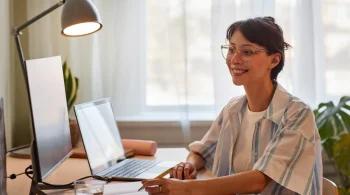 Woman in striped shirt smiling at a computer