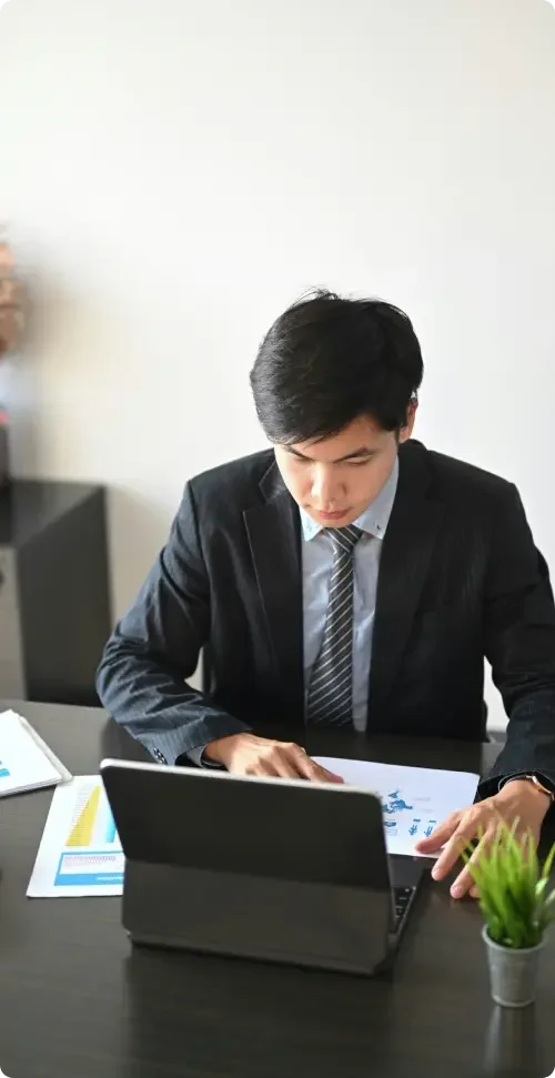 A business consultant who was hired on a contract basis sitting at a table and working on a laptop