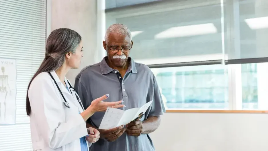 An elderly person discussing with a medical professional about a living will vs. an advance directive and which document is appropriate for his situation.