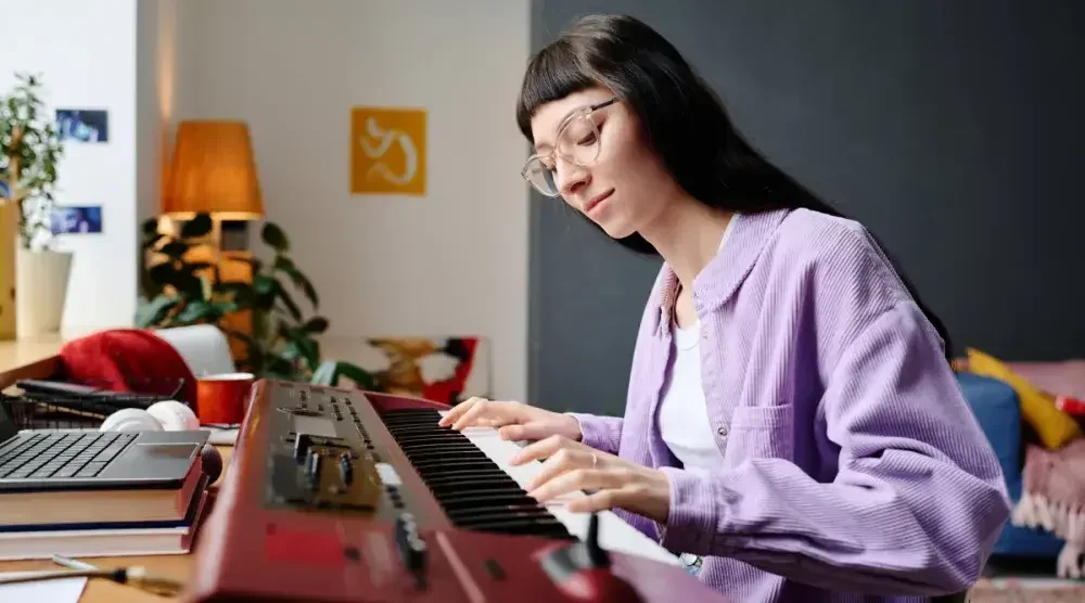 A young piano teacher plays a tune after forming her LLC in North Carolina.