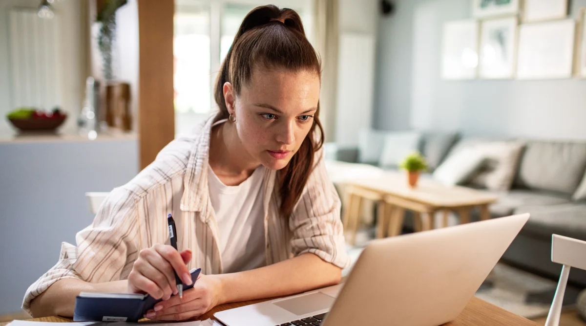 Brunette woman with high ponytail on her computer researching how to get a Georgia EIN